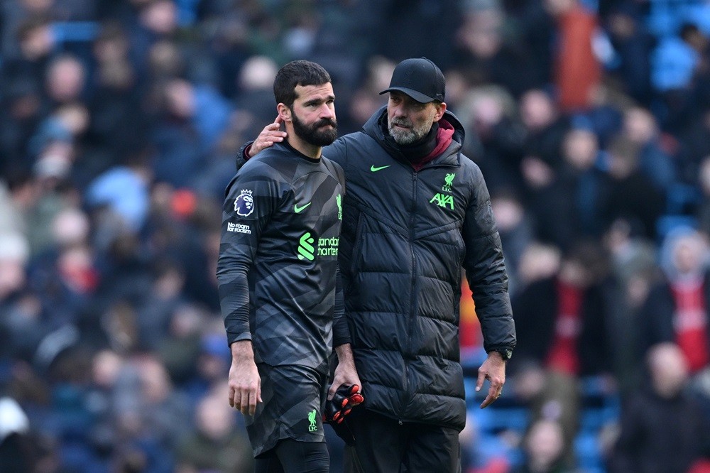 MANCHESTER, ENGLAND: A dejected Alisson Becker of Liverpool is consoled by Manager Juergen Klopp after he sustains an injury during the draw in the...