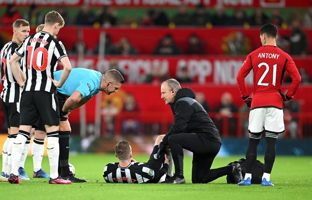 MANCHESTER, ENGLAND: Matt Targett of Newcastle United receives medical attention during the Carabao Cup Fourth Round match between Manchester Unite...