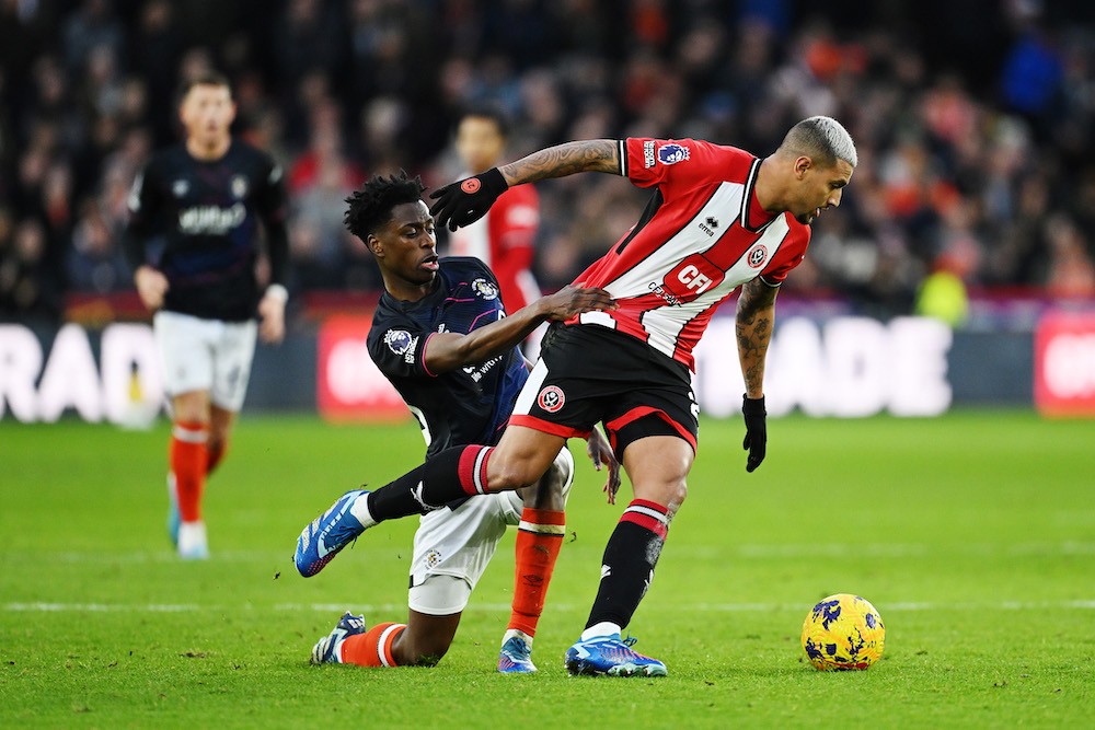SHEFFIELD, ENGLAND: Albert Sambi Lokonga of Luton Town challenges for the ball with Vinicius Souza of Sheffield United during the Premier League match between Sheffield United and Luton Town at Bramall Lane on December 26, 2023. (Photo by Michael Regan/Getty Images)