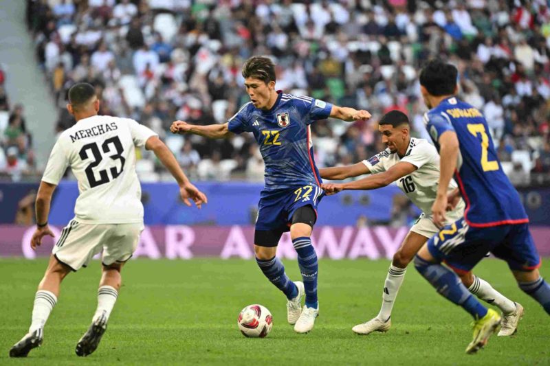 Iraq's midfielder #16 Amir al-Ammari fights for the ball with Japan's defender #22 Takehiro Tomiyasu during the Qatar 2023 AFC Asian Cup Group D fo...