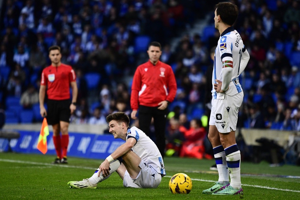 Real Sociedad's Kieran Tierney sits on the pitch next to Mikel Oyarzabal during the Spanish league football match between Real Sociedad and Real Be...