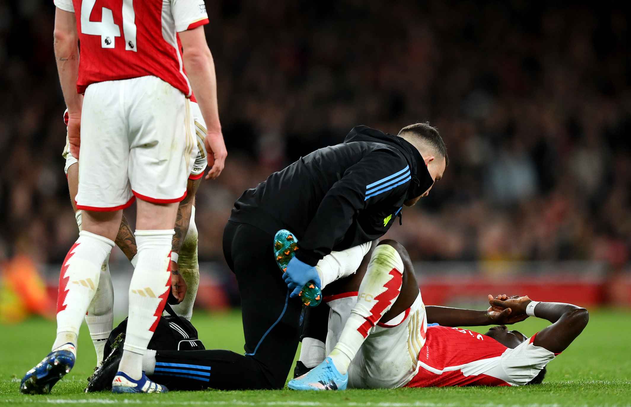 Bukayo Saka of Arsenal receives medical treatment during the Premier League match between Arsenal FC and Liverpool FC at Emirates Stadium on Februa...