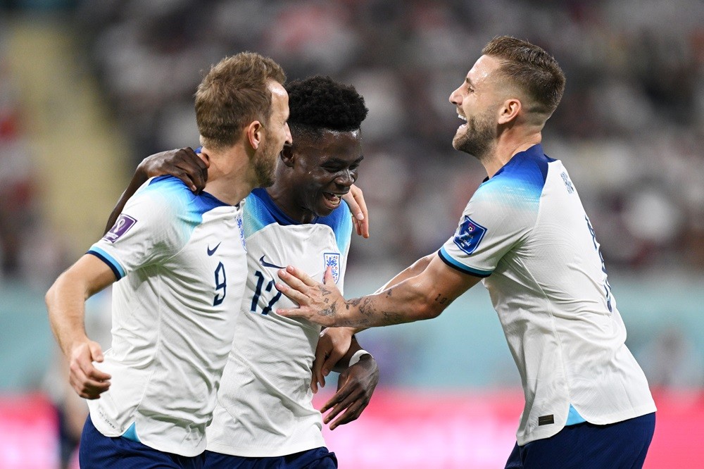 DOHA, QATAR: Bukayo Saka (C) of England celebrates scoring his team's fourth goal with their teammates Harry Kane (L) and Luke Shaw (R) during the ...