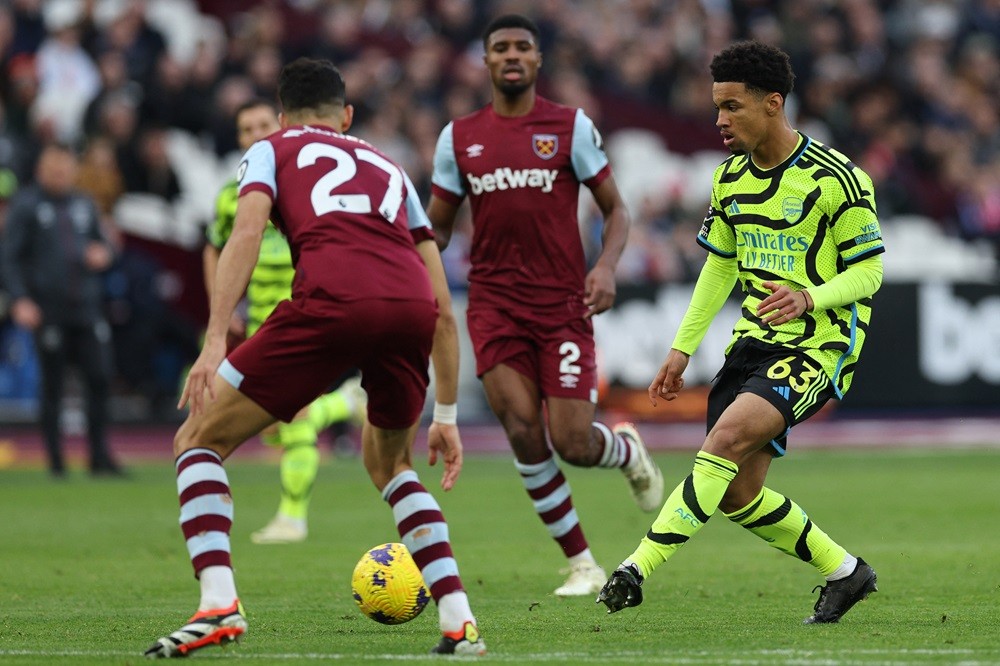 Arsenal's Ethan Nwaneri (R) passes the ball during the English Premier League football match between West Ham United and Arsenal at the London Stad...