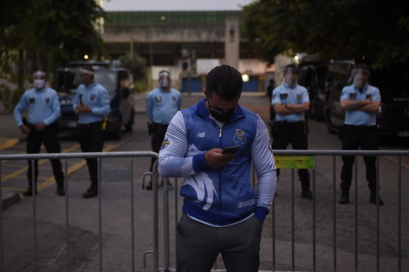 A FC Porto supporter stands in front of policemen outside the Municipal Stadium in Vila Nova de Famalicao on June 03, 2020 during the Portuguese le...