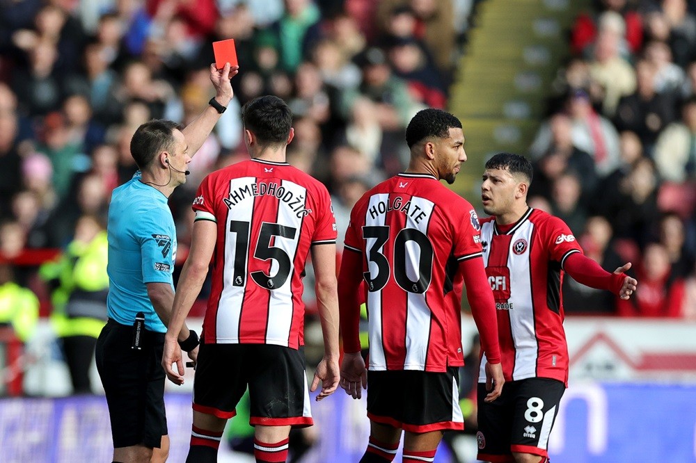 SHEFFIELD, ENGLAND: Referee Stuart Attwell shows a red card to Mason Holgate of Sheffield United after a VAR review during the Premier League match...