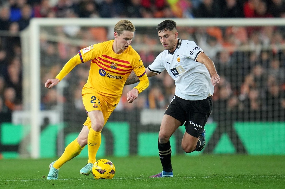 VALENCIA, SPAIN: Frenkie de Jong of FC Barcelona runs with the ball whilst under pressure from Hugo Duro of Valencia CF during the LaLiga EA Sports match between Valencia CF and FC Barcelona at Estadio Mestalla on December 16, 2023. (Photo by Aitor Alcalde/Getty Images)