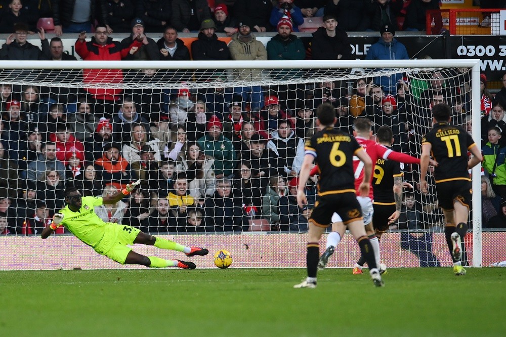 Arsenal loanee keeps 10th league clean sheet of the season 3 WREXHAM, WALES: Arthur Okonkwo of Wrexham saves a penalty from Andy Cook of Bradford City during the Sky Bet League Two match between Wrexham and Bradford City at Racecourse Ground on February 10, 2024. (Photo by Ben Roberts Photo/Getty Images)