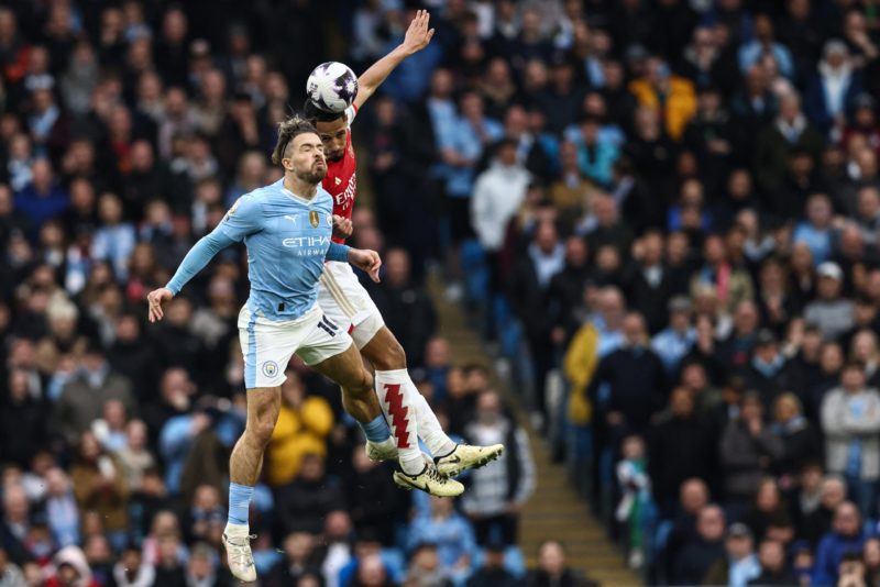 Manchester City's English midfielder #10 Jack Grealish (L) fights for the ball with Arsenal's French defender #02 William Saliba (R) during the Eng...