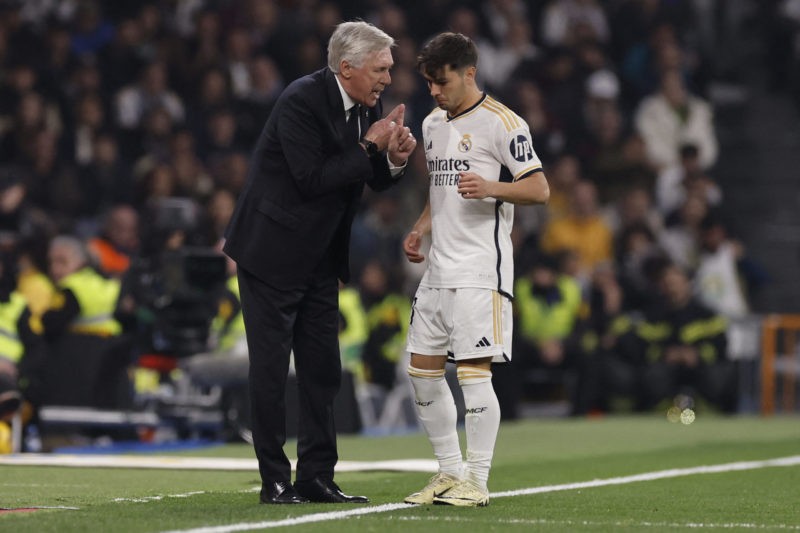 Real Madrid's Italian coach Carlo Ancelotti talks with Real Madrid's Spanish forward #21 Brahim Diaz (R) during the Spanish league football match b...