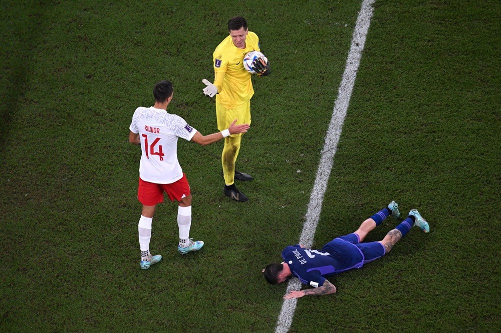 Argentina's Rodrigo De Paul reacts after failing to score next to Poland's Wojciech Szczesny and Jakub Kiwior during the Qatar 2022 World Cup Group C football match between Poland and Argentina at Stadium 974 in Doha on November 30, 2022. (Photo by KIRILL KUDRYAVTSEV/AFP via Getty Images)
