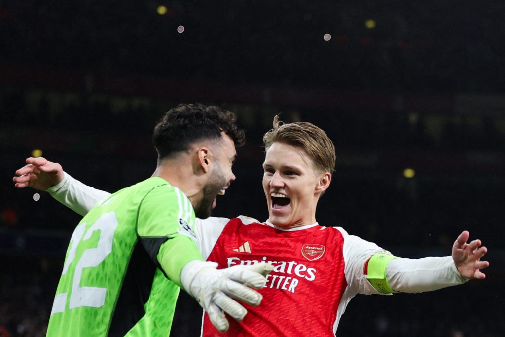 TOPSHOT - Arsenal's Spanish goalkeeper #22 David Raya and Arsenal's Norwegian midfielder #08 Martin Odegaard celebrate after winning the penalty shoot-out session of the UEFA Champions League last 16 second leg football match between Arsenal and Porto FC at the Arsenal Stadium in north London, on March 12, 2024. Arsenal edged out Porto on penalties to reach the Champions League quarter-finals for the first time since 2010. (Photo by Adrian DENNIS / AFP) (Photo by ADRIAN DENNIS/AFP via Getty Images)