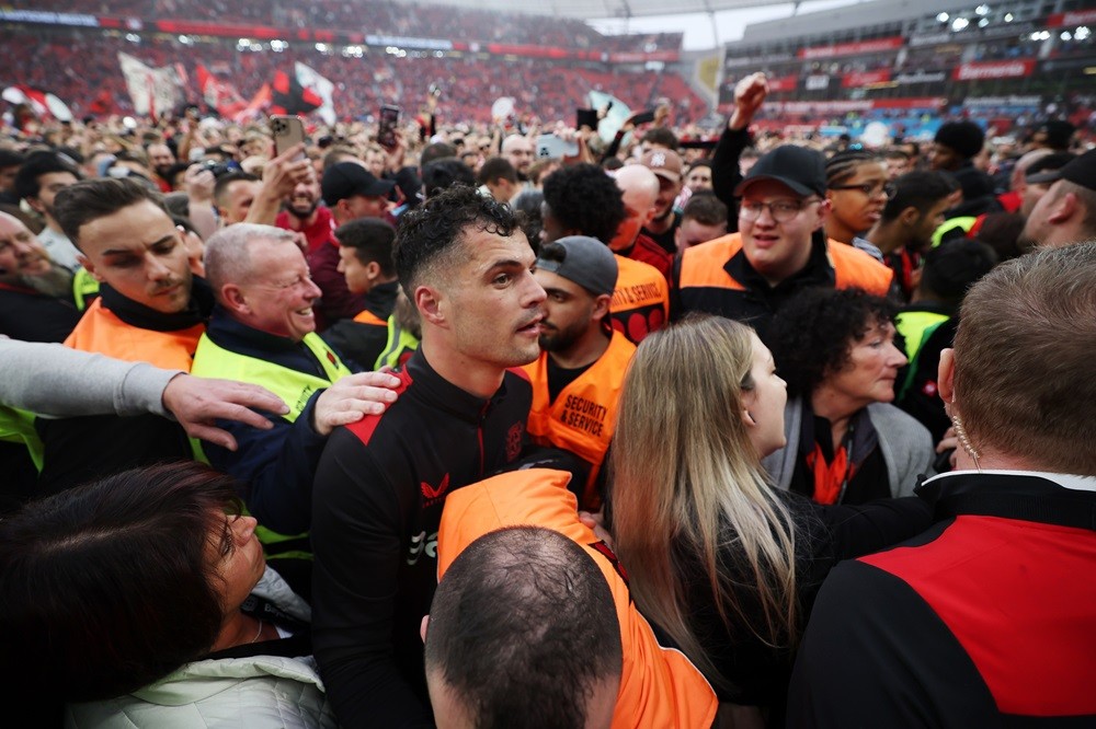 LEVERKUSEN, GERMANY: Granit Xhaka of Bayer Leverkusen celebrates with fans who have invaded the pitch after the team's victory and winning the Bund...