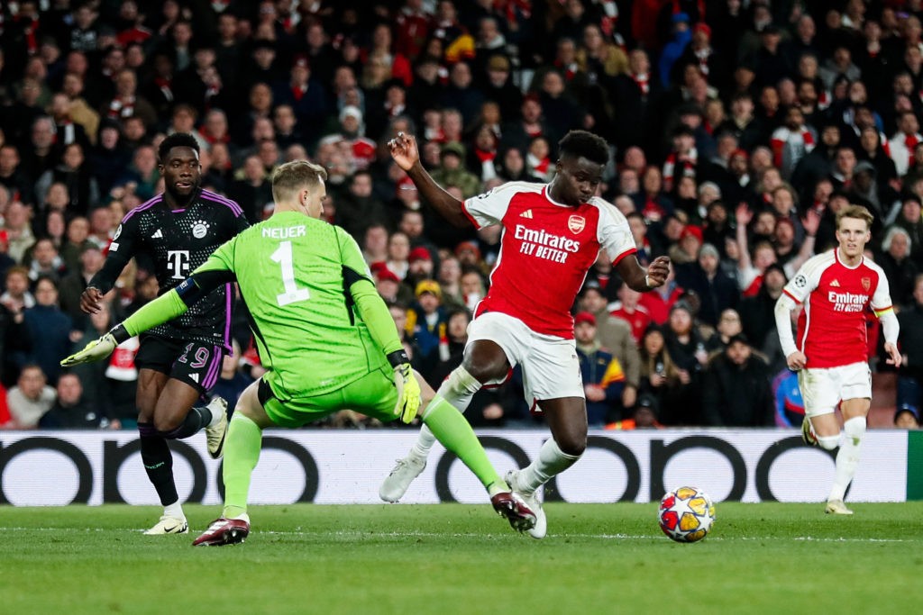 Bayern Munich's German goalkeeper #01 Manuel Neuer tackles Arsenal's English midfielder #07 Bukayo Saka during the UEFA Champions League quarter final first-leg football match between Arsenal and Bayern Munich at the Arsenal Stadium, in north London, on April 9, 2024. (Photo by IAN KINGTON/IKIMAGES/AFP via Getty Images)