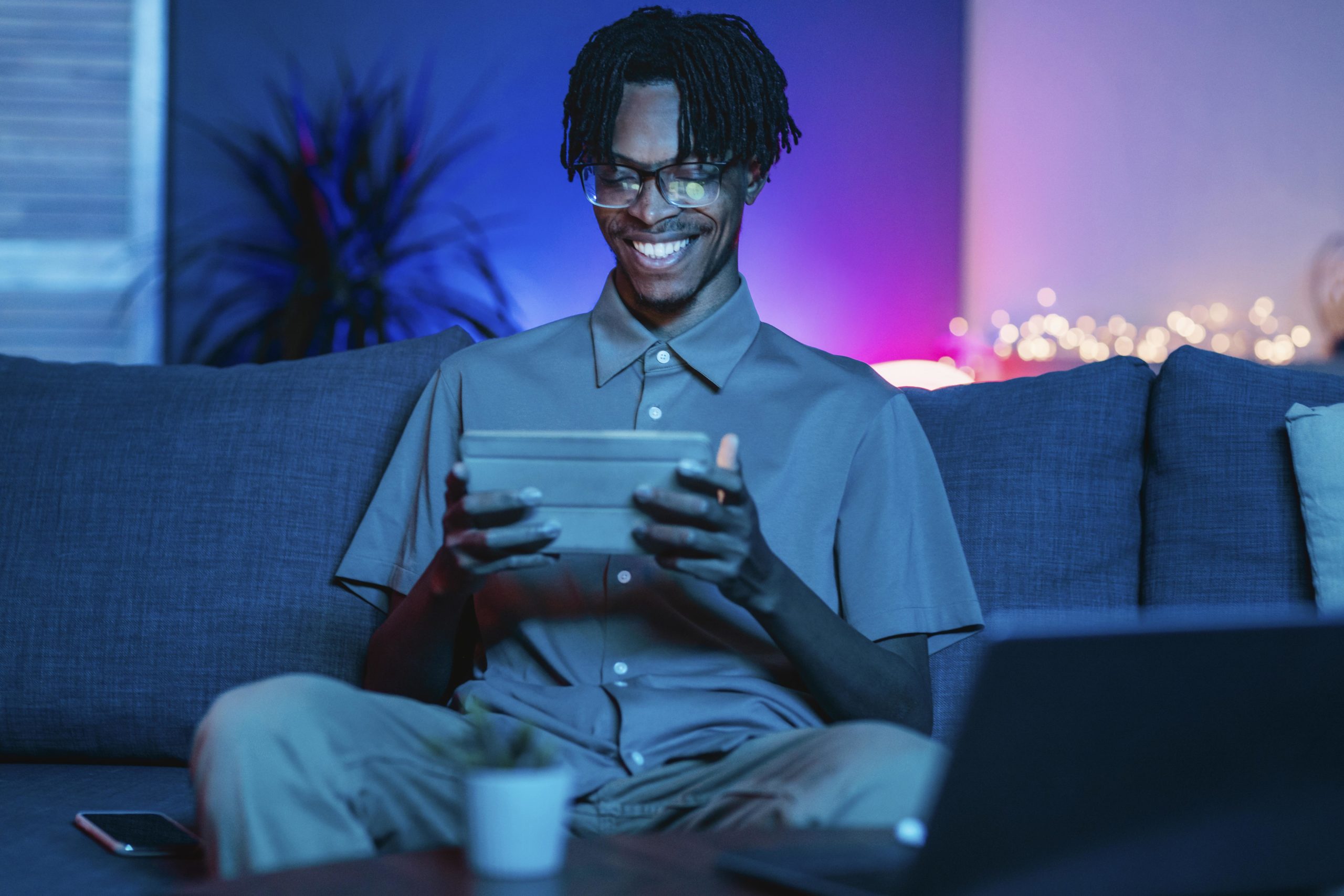 happy-man-using-his-tablet-home-couch