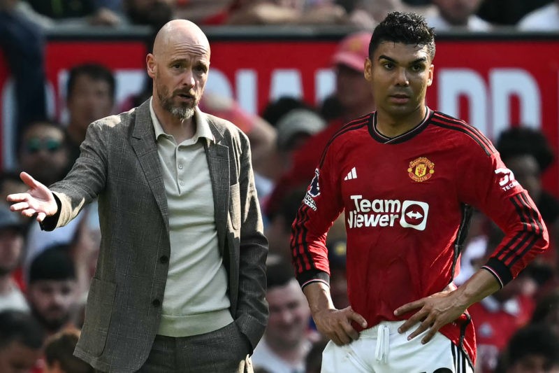 Manchester United's Dutch manager Erik ten Hag (L) talks to Manchester United's Brazilian midfielder #18 Casemiro during the English Premier League...