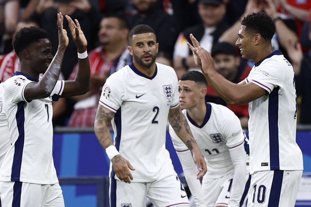 England's Jude Bellingham (R) celebrates scoring the opening goal with his Bukayo Saka (L) during the UEFA Euro 2024 Group C football match between...