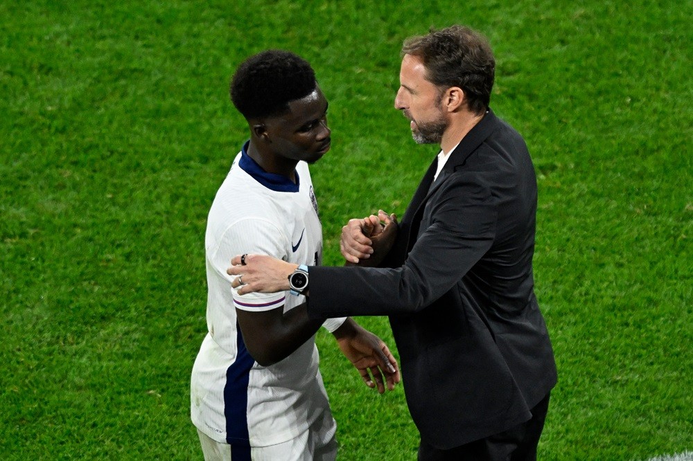 England's head coach Gareth Southgate speaks to Bukayo Saka after his substitution during the UEFA Euro 2024 Group C football match between Serbia ...