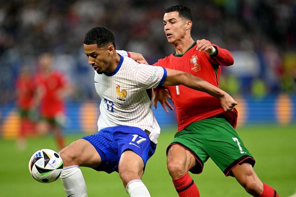 France's defender #17 William Saliba and Portugal's forward #07 Cristiano Ronaldo fight for the ball during the UEFA Euro 2024 quarter-final footba...