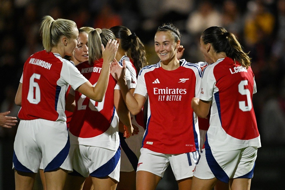 BOREHAMWOOD, ENGLAND: Caitlin Foord of Arsenal (C) celebrates scoring her team's sixth and her fourth goal with teammates during the UEFA Women's C...