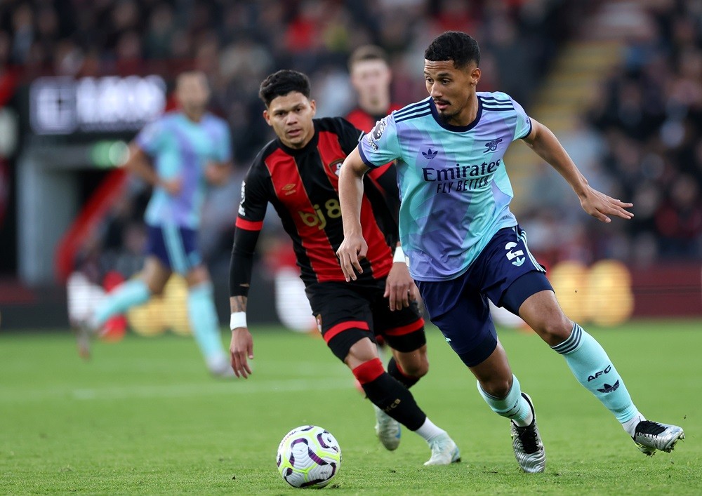 BOURNEMOUTH, ENGLAND: William Saliba of Arsenal runs with the ball whilst under pressure from Evanilson of AFC Bournemouth (obscured) during the Pr...