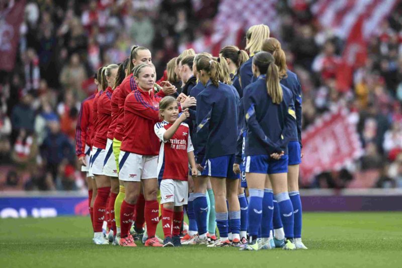 LONDON, ENGLAND - OCTOBER 06: Team Arsenal and Team Everton high five young girls on the pitch before the Barclays Women's Super League match betwe...