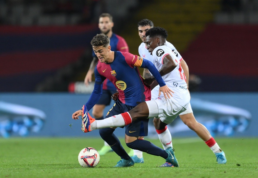 BARCELONA, SPAIN: Gavi of FC Barcelona runs with the ball whilst under pressure from Albert Sambi Lokonga of Sevilla FC during the La Liga EA Sports match between FC Barcelona and Sevilla FC at Estadi Olimpic Lluis Companys on October 20, 2024. (Photo by David Ramos/Getty Images)