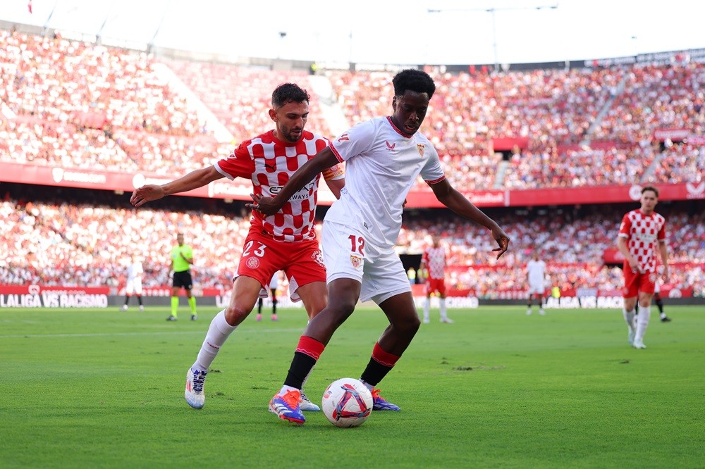 SEVILLE, SPAIN: Albert Sambi Lokonga of Sevilla FC controls the ball whilst under pressure from Ivan Martin of Girona FC during the LaLiga match between Sevilla FC and Girona FC at Estadio Ramon Sanchez Pizjuan on September 01, 2024. (Photo by Fran Santiago/Getty Images)