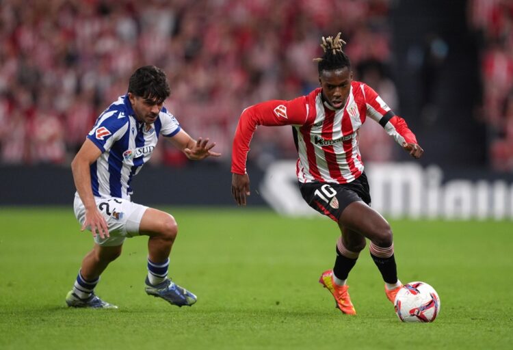 BILBAO, SPAIN: Nico Williams of Athletic Club runs with the ball under pressure from Jon Mikel Aramburu of Real Sociedad during the LaLiga match be...