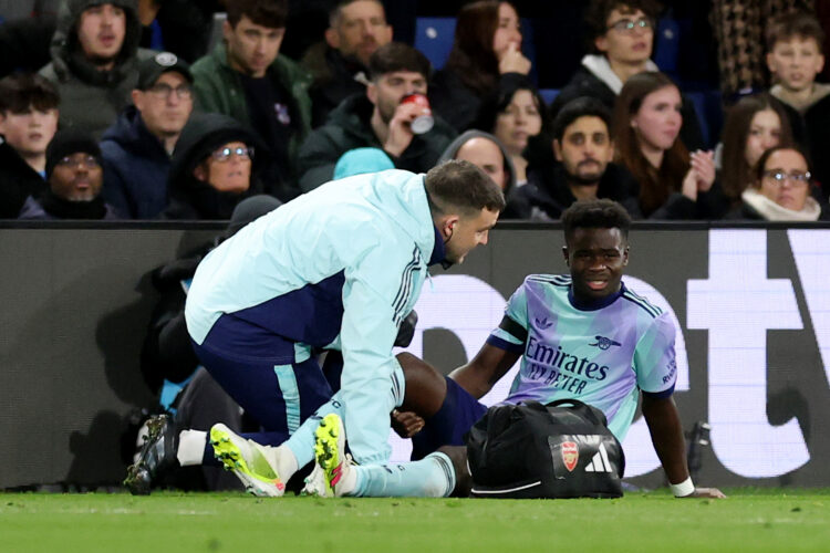 LONDON, ENGLAND - DECEMBER 21: Bukayo Saka of Arsenal receives medical treatment after picking up an injury during the Premier League match between...
