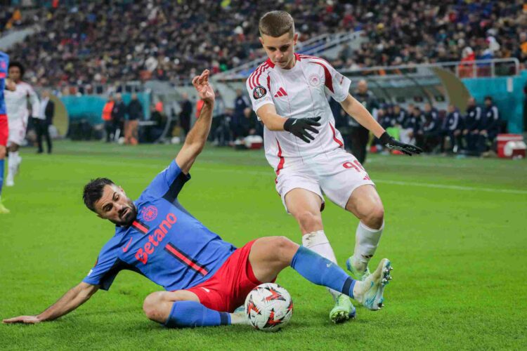 BUCHAREST, ROMANIA - NOVEMBER 28: Valentin Cretu (L) of FCSB battles for the ball with Christos Mouzakitis (R) of Olympiacos during the UEFA Europa...