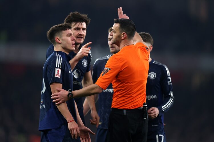 LONDON, ENGLAND: Referee Andrew Madley gestures towards Manuel Ugarte and Harry Maguire of Manchester United during the Emirates FA Cup Third Round...
