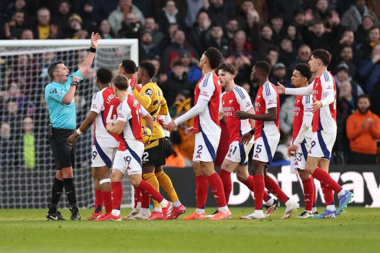 WOLVERHAMPTON, ENGLAND: Players of Arsenal protest to Referee Michael Oliver after Myles Lewis-Skelly of Arsenal is shown a red card for a foul on ...