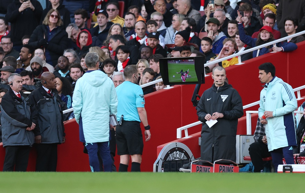 LONDON, ENGLAND: Referee Craig Pawson reviews the VAR monitor, resulting in Myles Lewis-Skelly of Arsenal (not pictured) receiving a red card, for denying a potential goal-scoring opportunity during the Premier League match between Arsenal FC and West Ham United FC at Emirates Stadium on February 22, 2025. (Photo by Julian Finney/Getty Images)