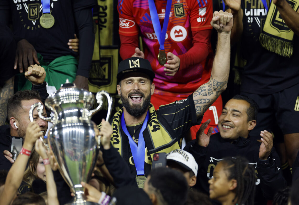 LOS ANGELES, CALIFORNIA - SEPTEMBER 25: Olivier Giroud #9 of Los Angeles FC hoisting the championship trophy celebrates with teammates after defeat...
