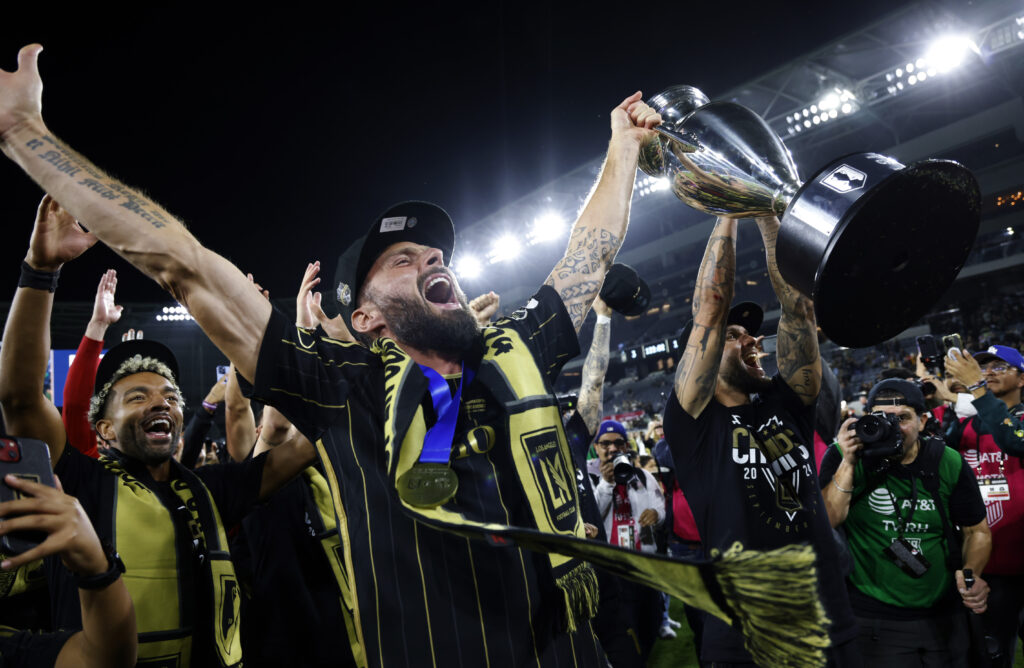 LOS ANGELES, CALIFORNIA - SEPTEMBER 25: Olivier Giroud #9 of Los Angeles FC hoisting the championship trophy celebrates with teammate as fans after defeating Sporting Kansas City, 3-1, in extra time during the U.S. Open Cup Championship match between Sporting Kansas City and Los Angeles Football Club at BMO Stadium on September 25, 2024 in Los Angeles, California. (Photo by Kevork Djansezian/Getty Images)