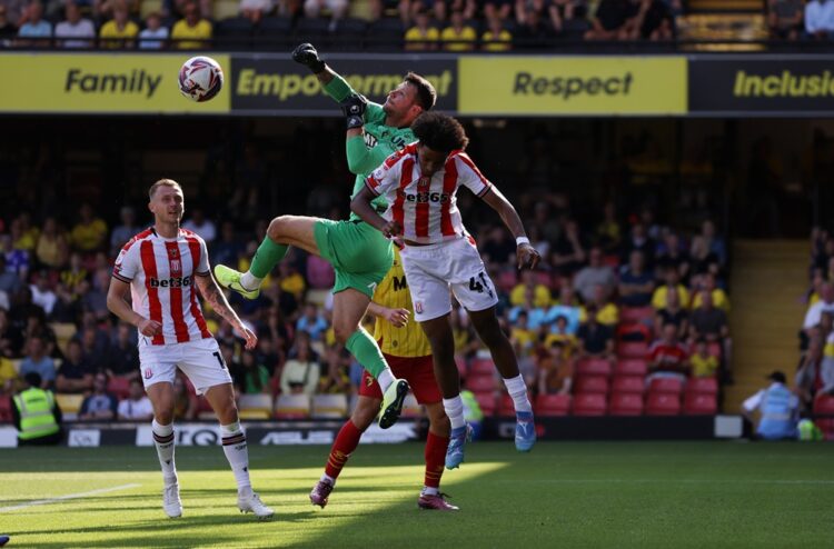 WATFORD, ENGLAND: Daniel Bachmann of Watford punches the ball clear under pressure from Jaden Dixon of Stoke City during the Sky Bet Championship m...