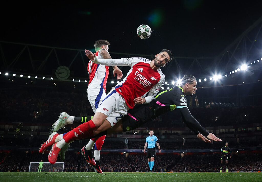 LONDON, ENGLAND - MARCH 12: Ben White and Mikel Merino of Arsenal compete for a header with Armando Obispo of PSV Eindhoven during the UEFA Champions League 2024/25 UEFA Champions League 2024/25 Round of 16 Second Leg match between Arsenal FC and PSV at Emirates Stadium on March 12, 2025 in London, England. (Photo by Ryan Pierse/Getty Images)