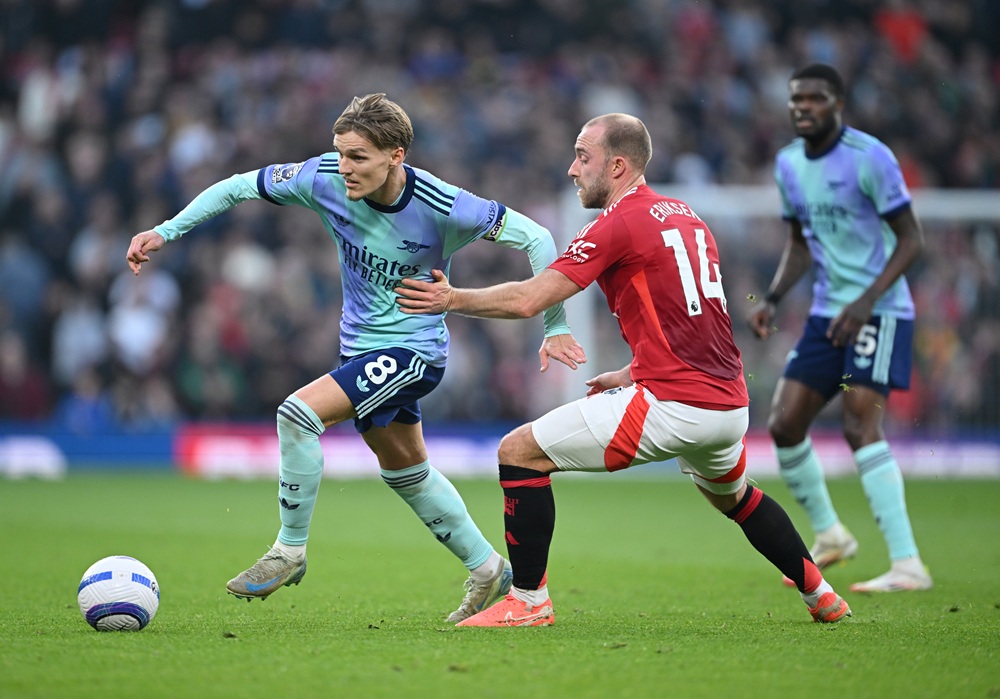 MANCHESTER, ENGLAND: Martin Odegaard of Arsenal is challenged by Christian Eriksen of Manchester United during the Premier League match between Manchester United FC and Arsenal FC at Old Trafford on March 09, 2025. (Photo by Michael Regan/Getty Images)