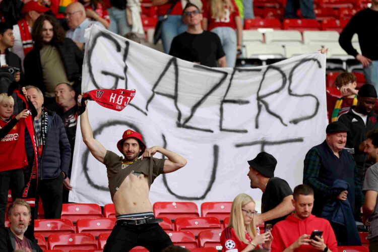MANCHESTER, ENGLAND - OCTOBER 07: Manchester United fans show their support while holding a banner which reads 'Glazers Out' following their sides ...