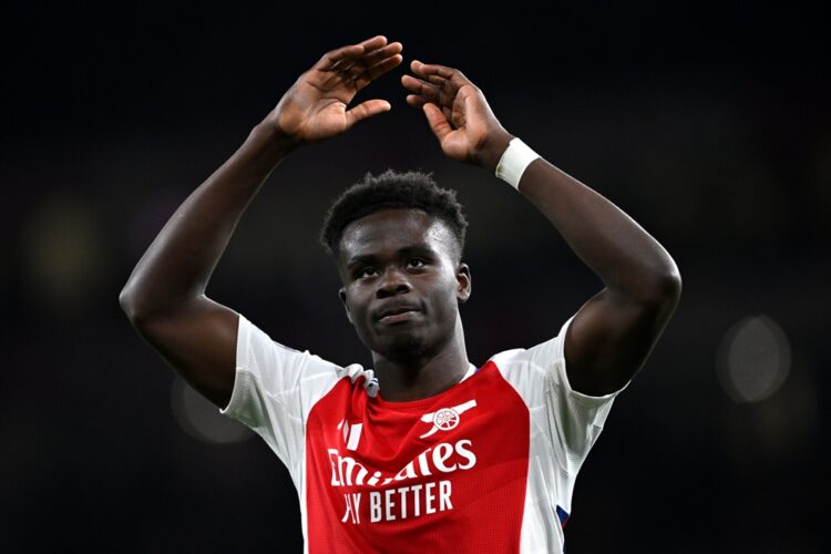 LONDON, ENGLAND: Bukayo Saka of Arsenal encourages the fans during the UEFA Champions League 2024/25 Quarter Final First Leg match between Arsenal ...