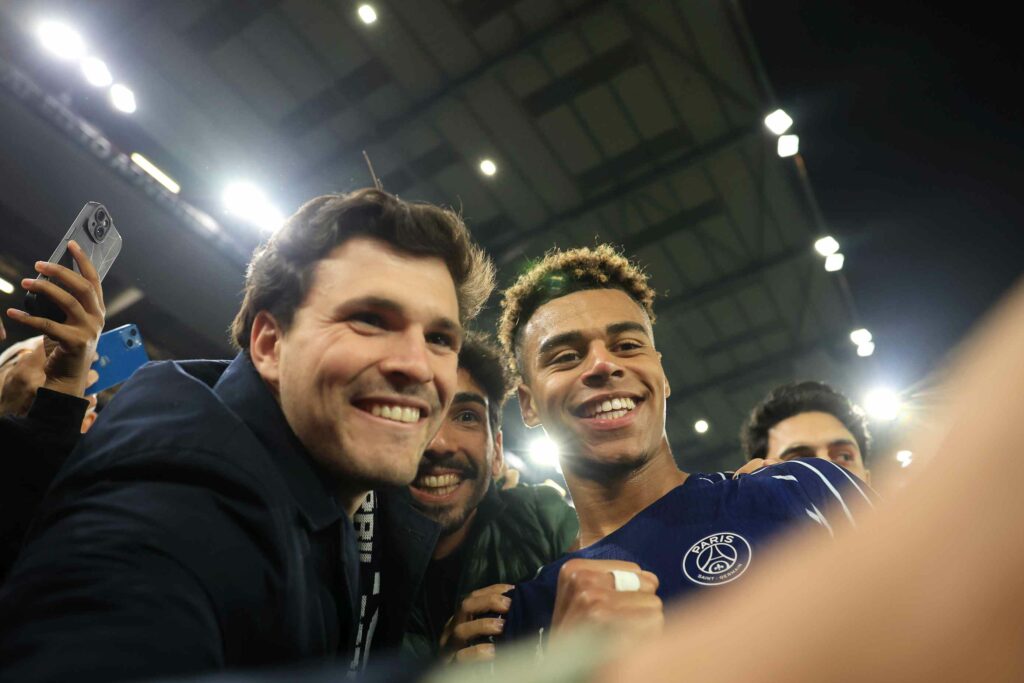BIRMINGHAM, ENGLAND - APRIL 15: Desire Doue of Paris Saint-Germain takes a selfie with fans of Paris Saint-Germain as they celebrate after Paris Saint-Germain defeat Aston Villa to progress through to the Semi-Finals after the UEFA Champions League 2024/25 Quarter Final Second Leg match between Aston Villa FC and Paris Saint-Germain at Villa Park on April 15, 2025 in Birmingham, England. (Photo by Carl Recine/Getty Images)
