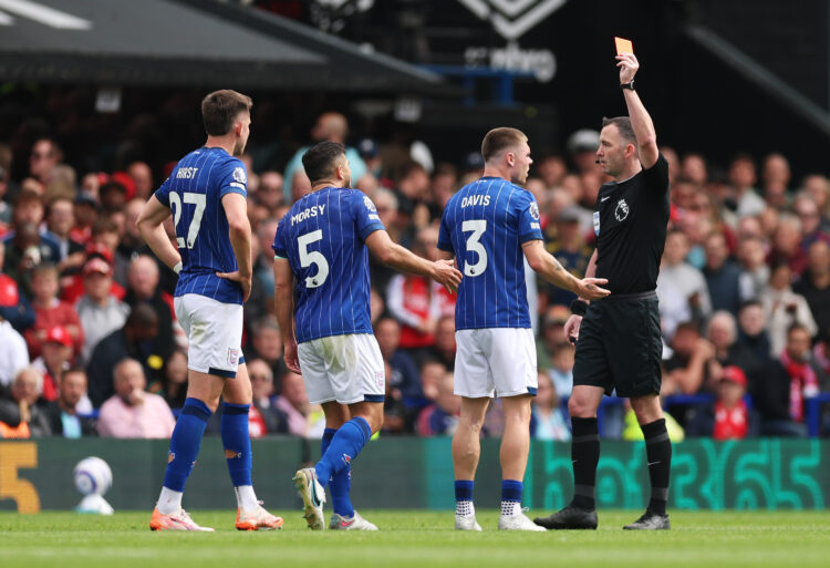 IPSWICH, ENGLAND - APRIL 20: Referee Chris Kavanagh shows a red card to Leif Davis of Ipswich Town, following a foul on Bukayo Saka of Arsenal (not...