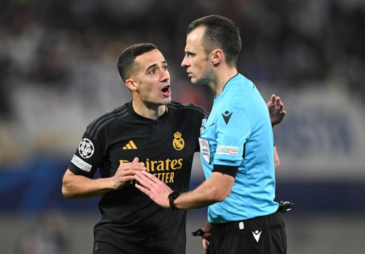 LEIPZIG, GERMANY: Lucas Vázquez of Real Madrid talks with referee Irfan Peljto during the UEFA Champions League 2023/24 round of 16 first leg match...