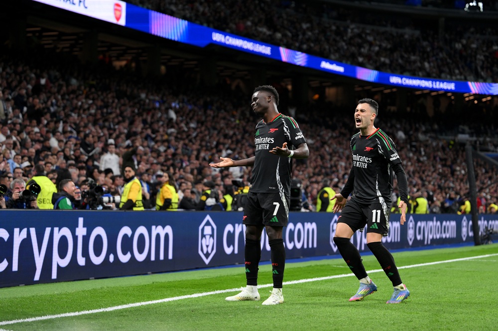 Barcelona fans mock Real Madrid with Arsenal flag at cup final 4 MADRID, SPAIN: Bukayo Saka of Arsenal celebrates scoring his team's first goal with teammate Gabriel Martinelli during the UEFA Champions League 2024/25 Quarter Final Second Leg match between Real Madrid C.F. and Arsenal FC at Estadio Santiago Bernabeu on April 16, 2025. (Photo by David Ramos/Getty Images)