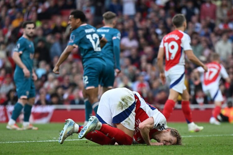 LONDON, ENGLAND: Martin Odegaard of Arsenal goes down with an injury during the Premier League match between Arsenal FC and AFC Bournemouth at Emir...