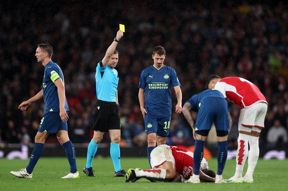 LONDON, ENGLAND: Referee Felix Zwayer shows a yellow card to Olivier Boscagli of PSV Eindhoven during the UEFA Champions League match between Arsenal FC and PSV Eindhoven at Emirates Stadium on September 20, 2023. (Photo by Alex Pantling/Getty Images)