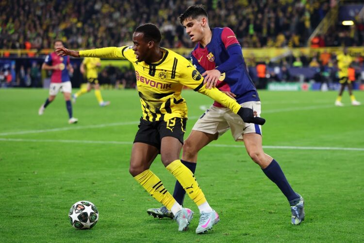 DORTMUND, GERMANY: Jamie Bynoe-Gittens of Borussia Dortmund battles for the ball with Gerard Martin of FC Barcelona during the UEFA Champions Leagu...