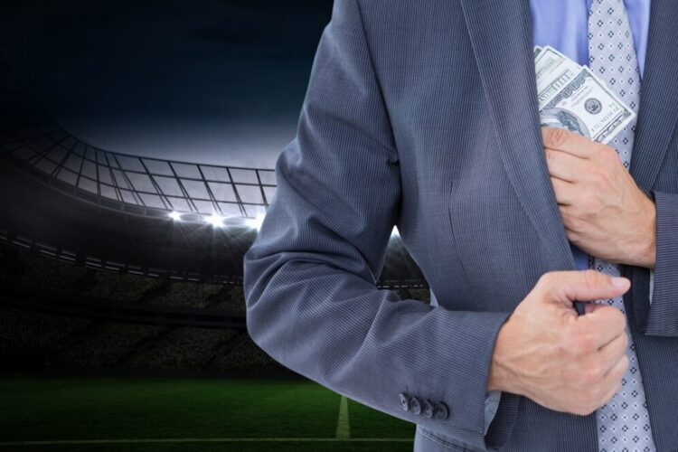 man in suit putting money in his pocket