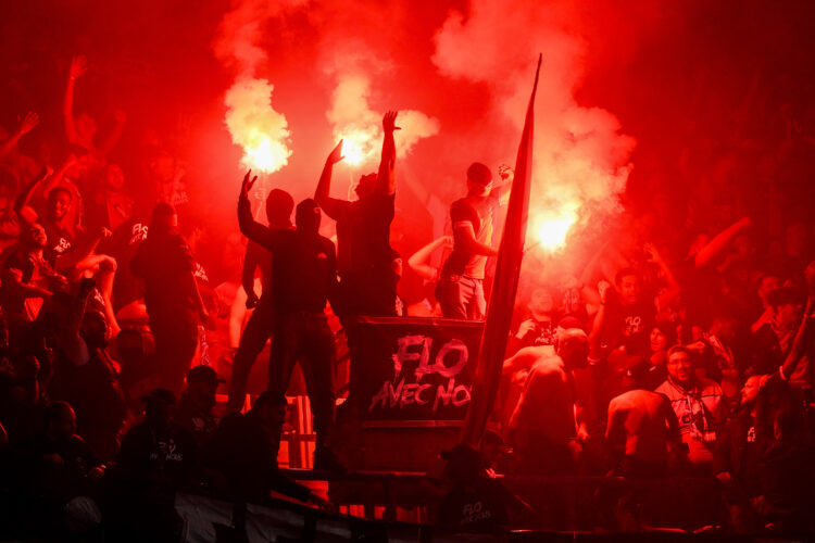 PARIS, FRANCE - MAY 07: Fans of Paris Saint-Germain light red flares in celebration following the team's victory and subsequent progression into th...